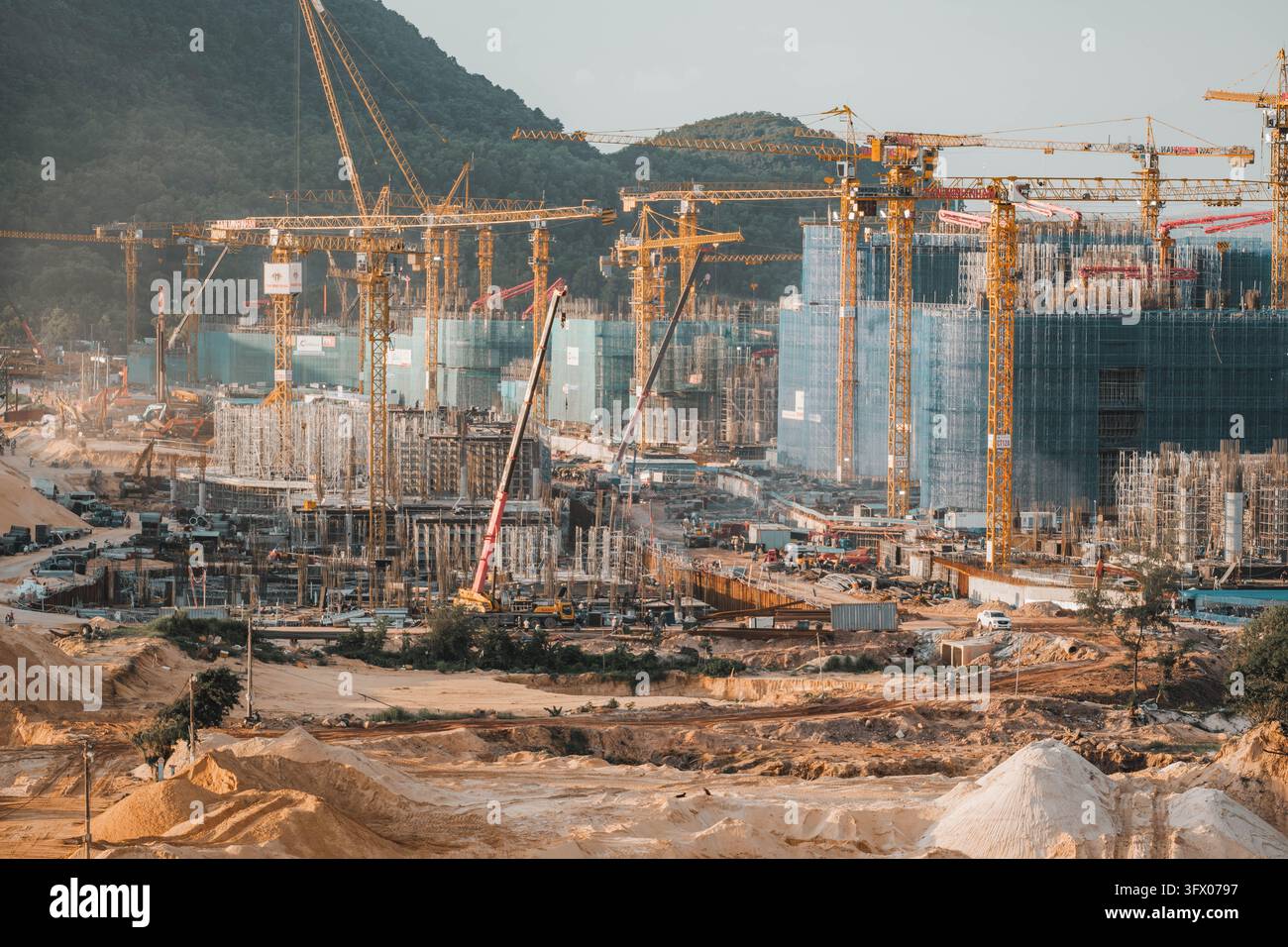 Phu Quoc, Vietnam, 21 ottobre 2026. Numerose gru circondano edifici in cemento incompiuti e strutture metalliche esposte in un grande cantiere di sviluppo Foto Stock