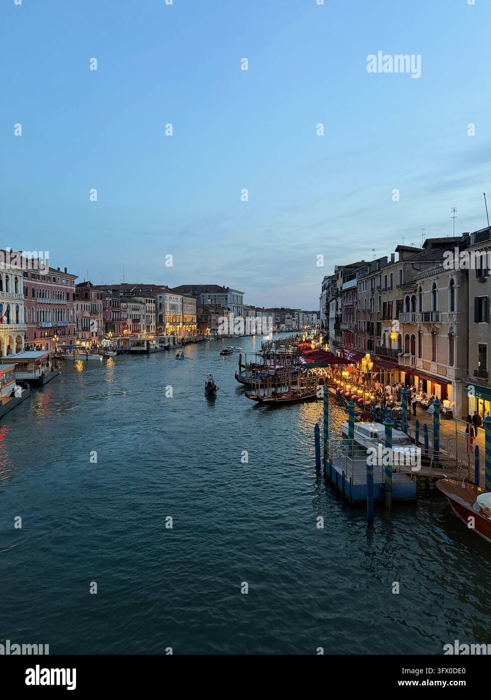 Bella vista serale del Canal Grande con edifici illuminati e gondole al crepuscolo a Venezia, Italia. - Immagine stock catturata con smartphone