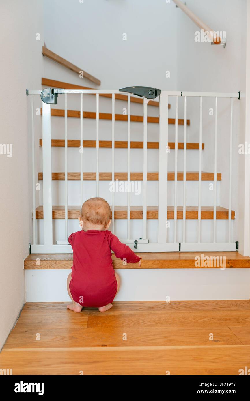 Bambino affascinante seduto vicino a un mazzo di fiori autunnali, posa con un'espressione facciale innocente in un caldo e accogliente abbigliamento autunnale, perfetto per la genitorialità e lo stile di vita Foto Stock