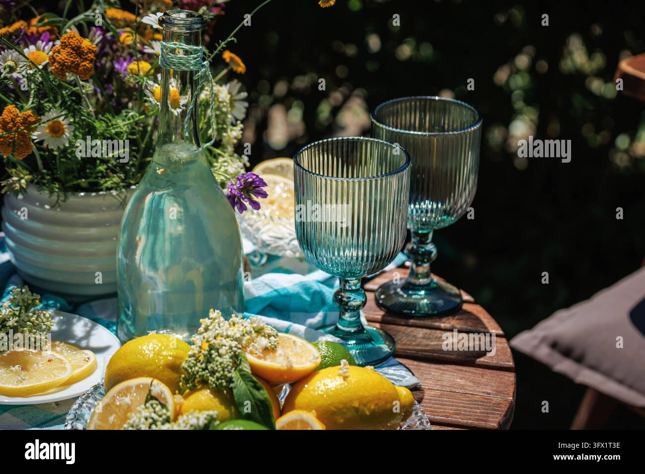 Tavolo da giardino rustico con limonata alla fiori di sambuco e agrumi Foto Stock