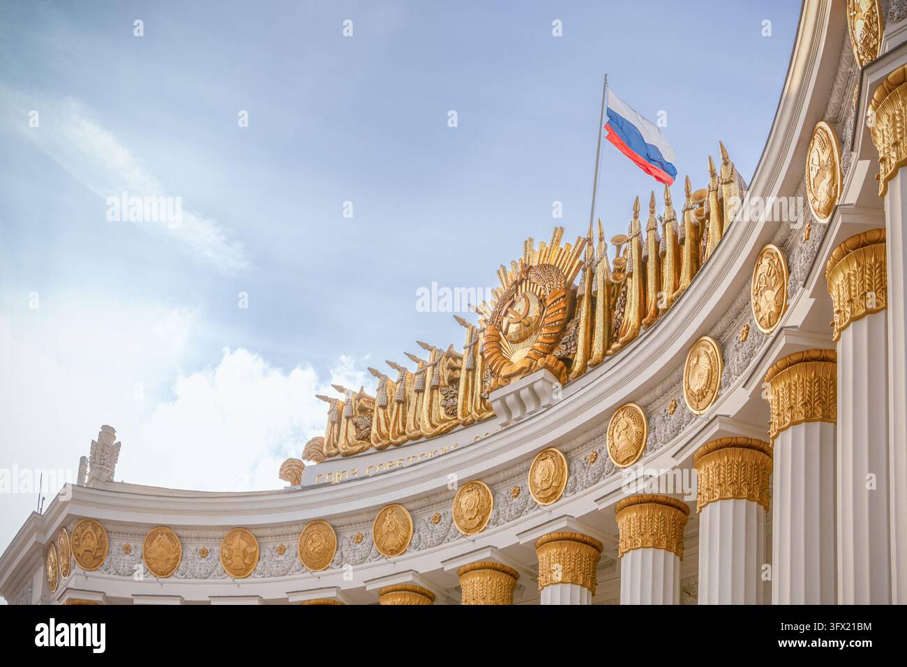 Mosca, Russia, 26 09 2026: Dettaglio architettonico dell'arco d'ingresso principale della VDNKh a Mosca, in Russia, con uno stemma dorato dell'Unione Sovietica, orna Foto Stock