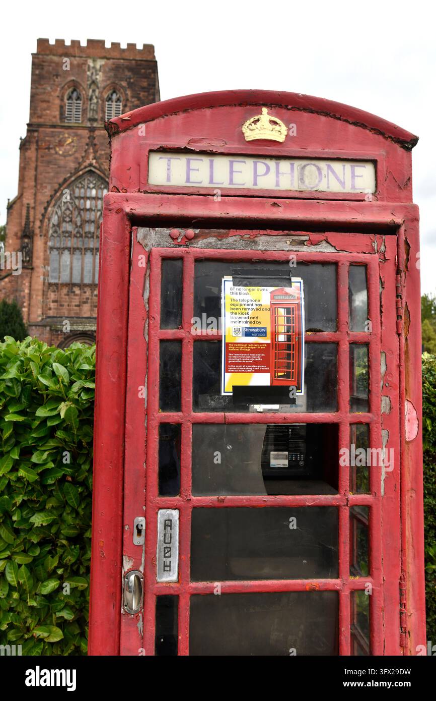 Un tradizionale chiosco telefonico rosso britannico in condizioni molto pessime con una nota di esclusione di responsabilità da parte di BT poiché la cabina è ora di proprietà del Comune di Shrewsbury. Foto Stock