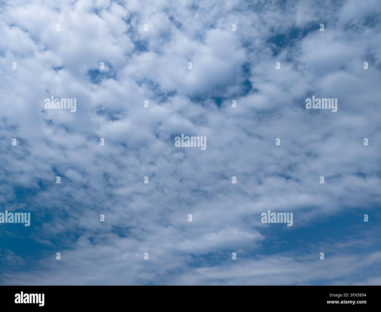 Cielo azzurro con nuvole bianche sparse in una giornata di sole Foto Stock