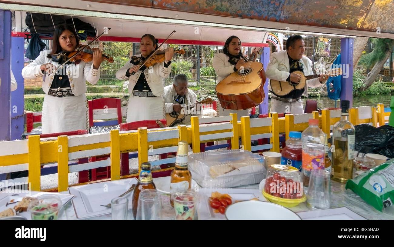 Xochimilco è noto per la sua rete di canali e per le trajineras dipinte di colori vivaci, dove i visitatori possono assumere musicisti per suonare a bordo delle barche. Foto Stock