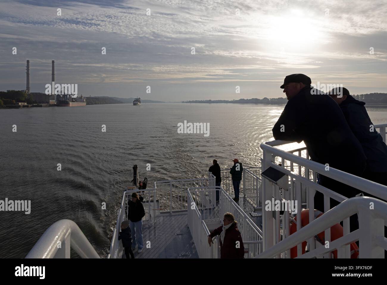 Centrale combinata calore ed energia elettrica, catamarano Halunder Jet in viaggio verso Heligoland, persone, controluce, silhouette, Elba, Wedel, Germania Foto Stock