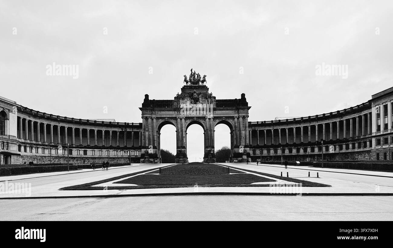Vista monocromo grandangolare dell'arco trionfale monumentale storico e della colonnata semicircolare nel Parco del Cinquantenaire. Foto Stock