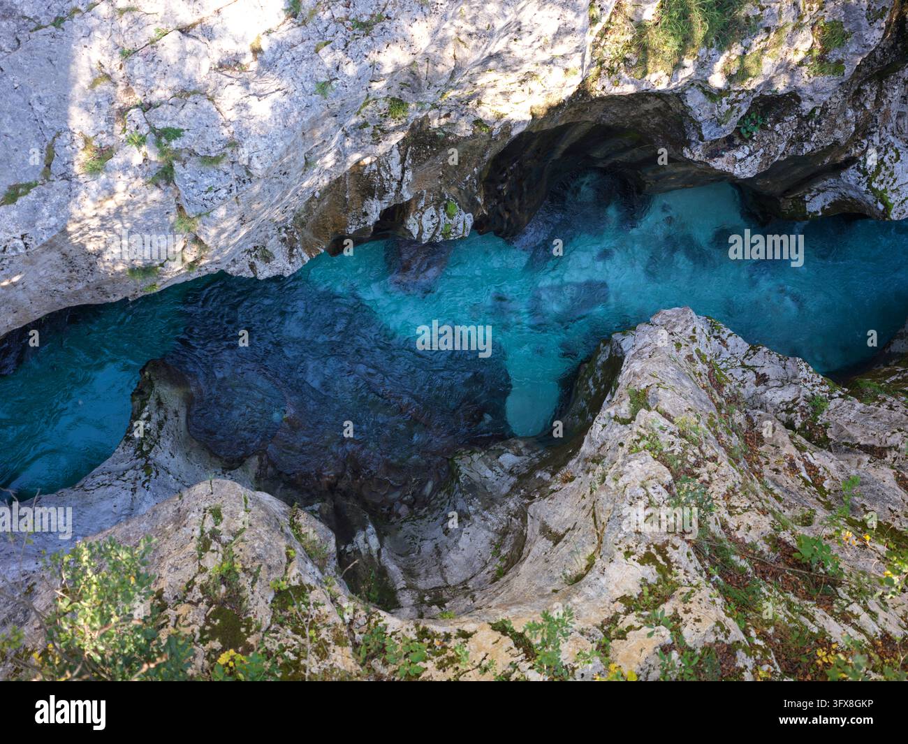 Vista ad angolo alto dell'acqua turchese del fiume che si snoda attraverso una stretta gola di calcare nell'area della valle del Soča in Slovenia Foto Stock