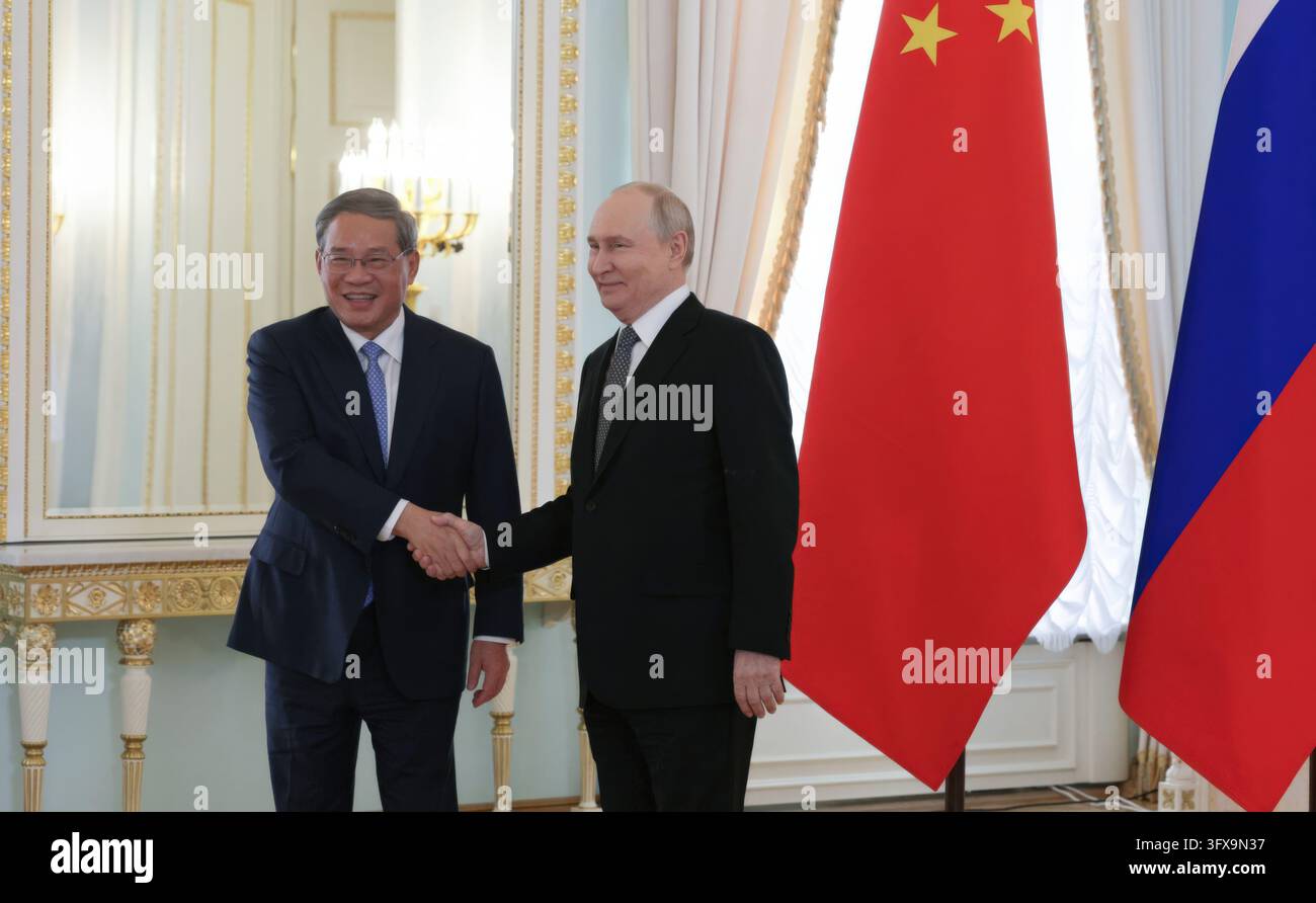 San Pietroburgo, Russia. 21 ottobre 2026. Il presidente russo Vladimir Putin saluta il Primo ministro cinese Li Qiang, a sinistra, prima di un incontro bilaterale al Palazzo Costantino, il 21 ottobre 2026 a Strelna, fuori San Pietroburgo, RussiaCredit: Gavriil Grigorov/Kremlin Pool/Alamy Live News Foto Stock
