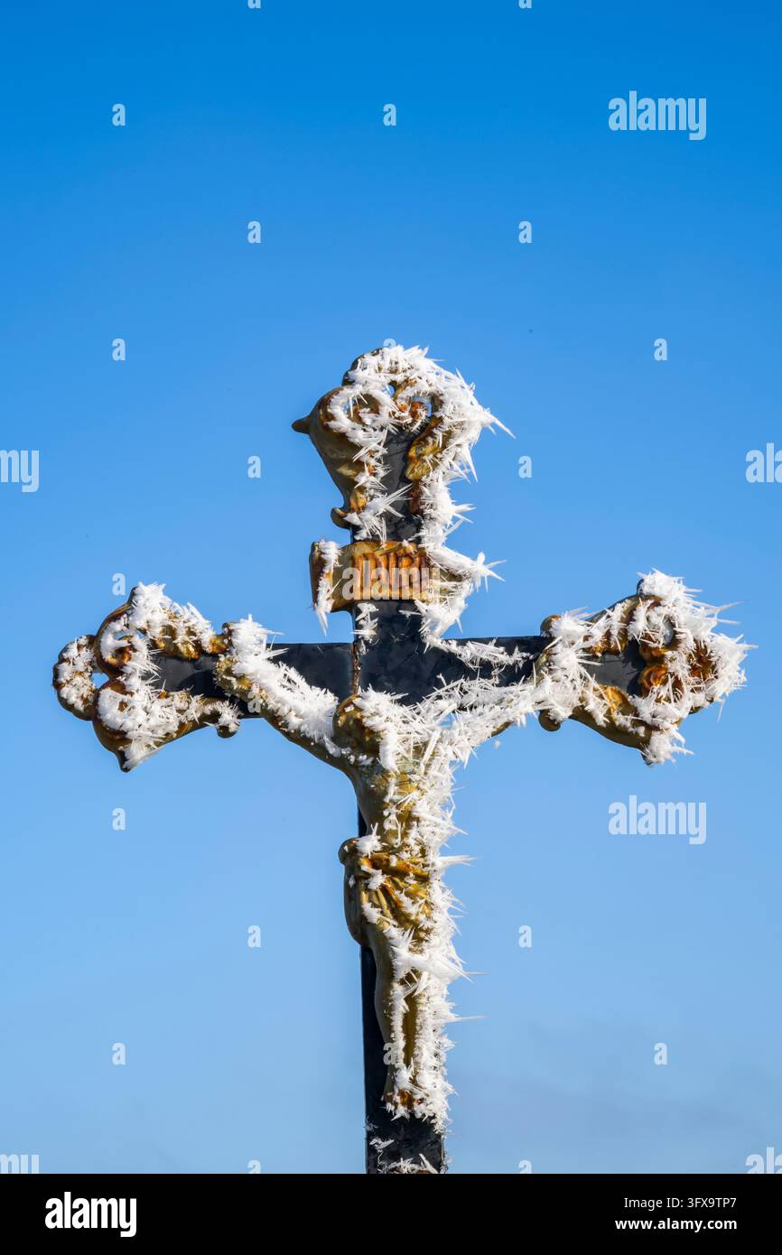 Crocifisso con parrucchiere davanti al cielo azzurro al sole in inverno, Baviera, Germania, Europa Foto Stock