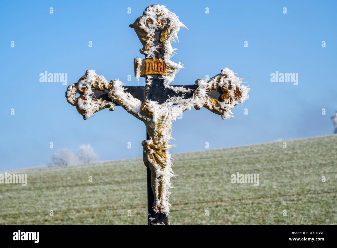 Crocifisso con parrucchiere davanti al cielo azzurro al sole in inverno, Baviera, Germania, Europa Foto Stock