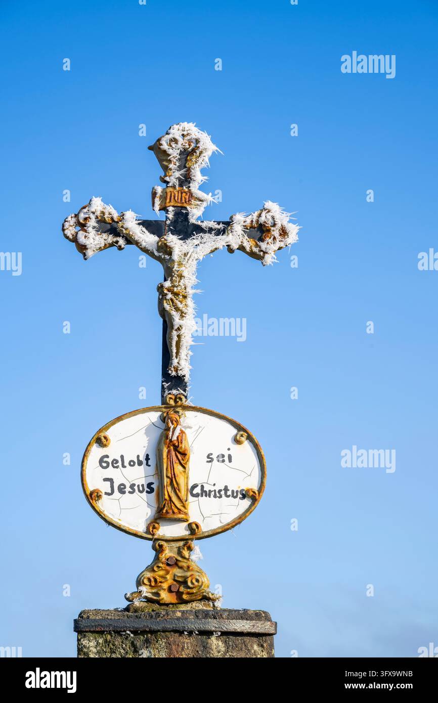 Crocifisso con parrucchiere davanti al cielo azzurro al sole in inverno, Baviera, Germania, Europa Foto Stock