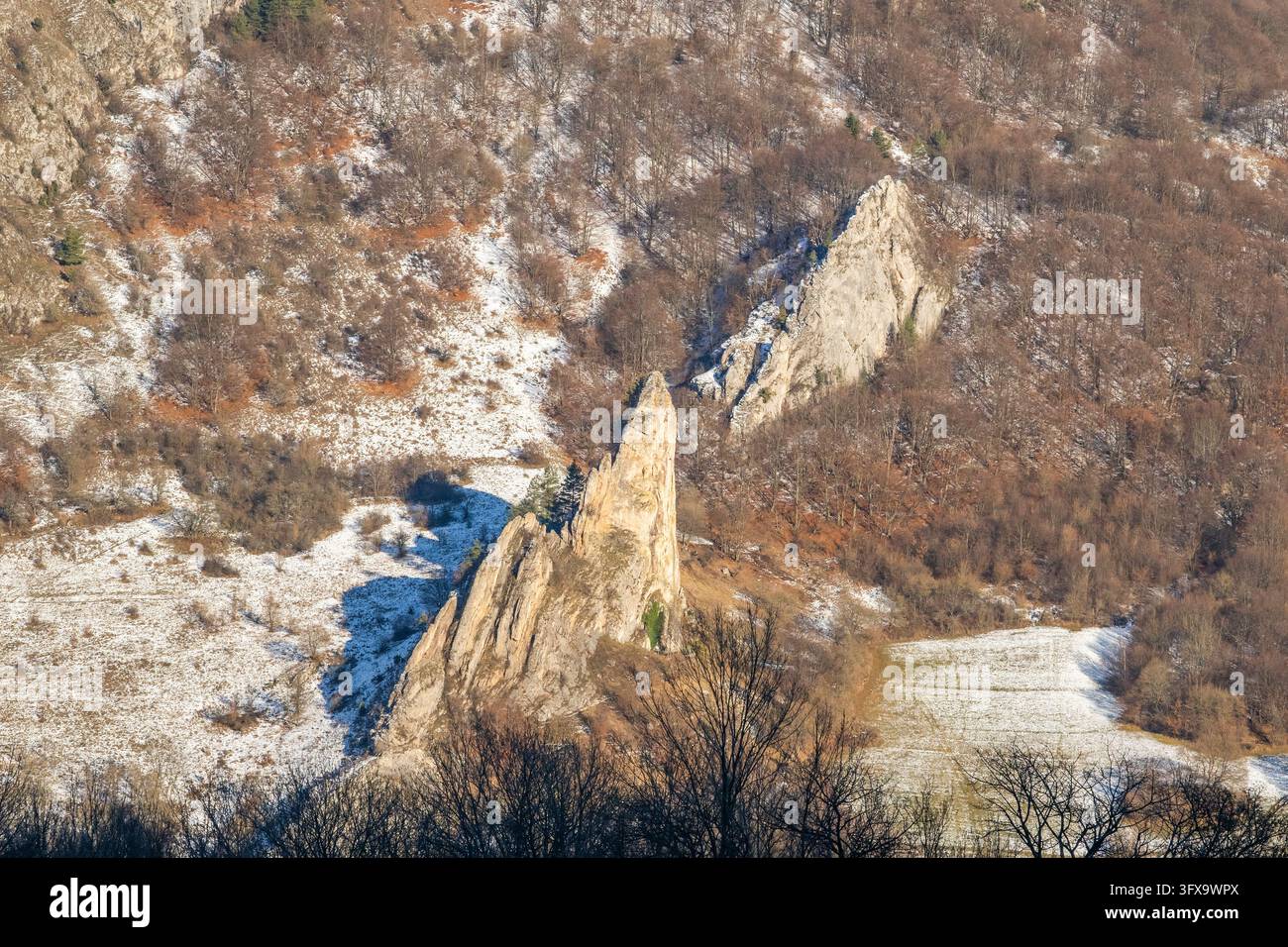 Scogliera di Červenokamenské (cervenokamenske bradlo), un enorme masso con cespugli, alberi e prati in inverno, Vápeč, Horná Poruba, Slovacchia Foto Stock