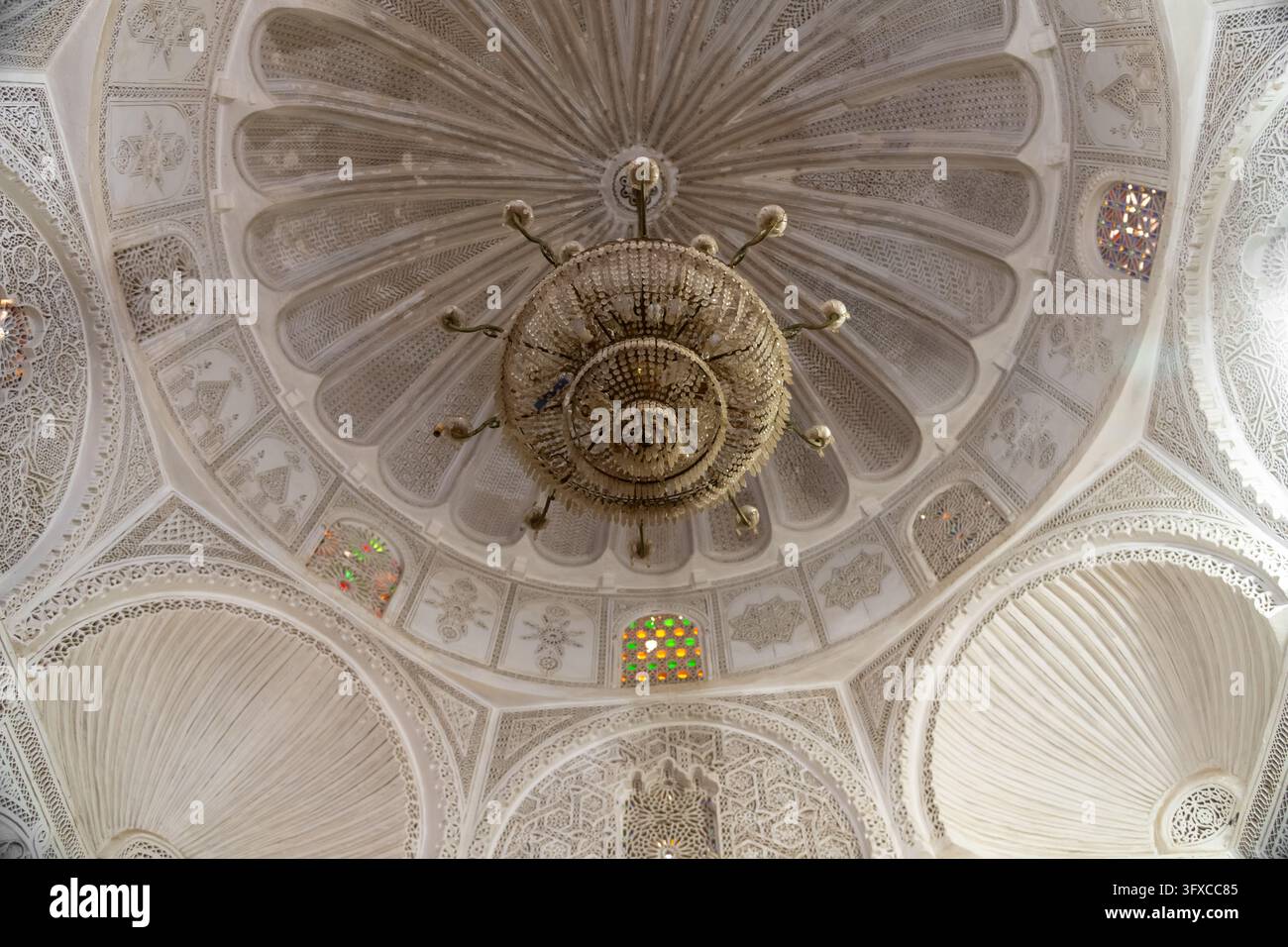 Interno di cupola in gesso intagliato ornato con lampadario centrale in ottone e motivi geometrici radiali in Foto Stock