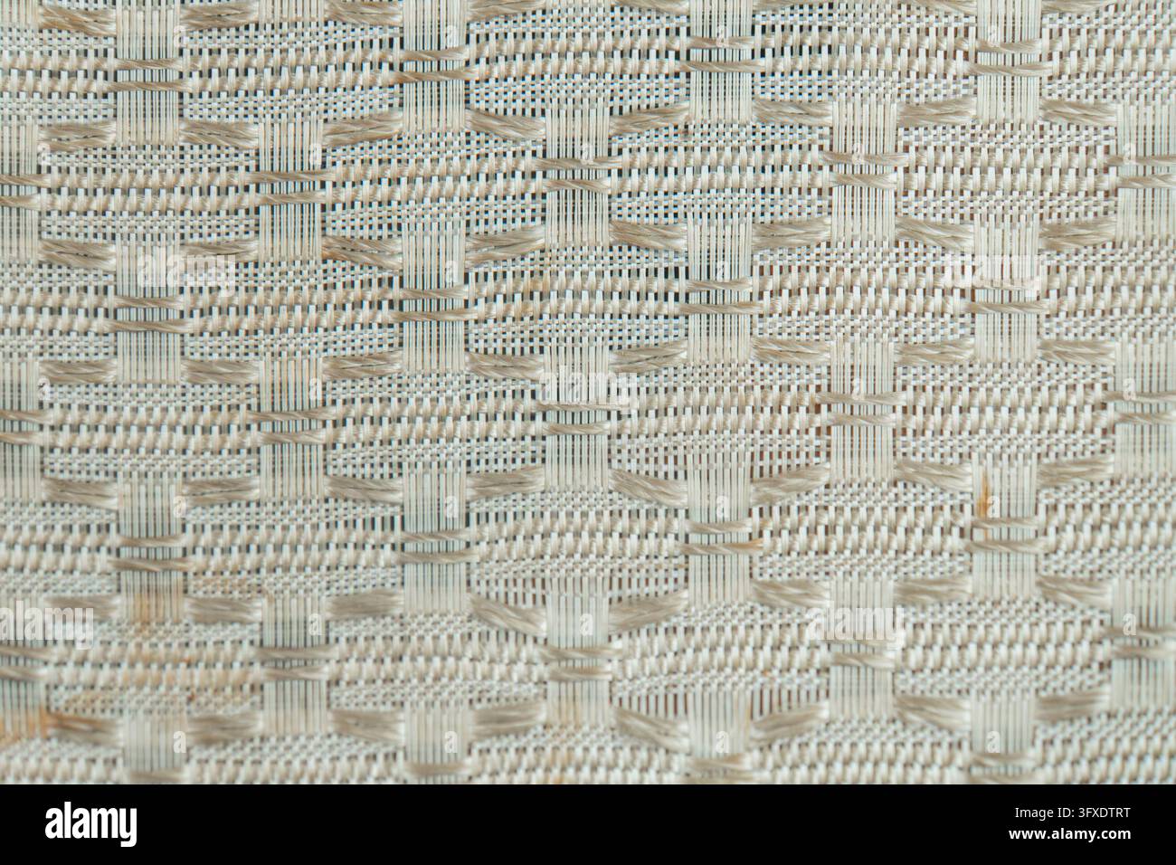 Primo piano di un tessuto intricato e densamente tessuto con marroni e beige smorzati I fili sovrapposti creano un effetto tridimensionale e strutturato Foto Stock