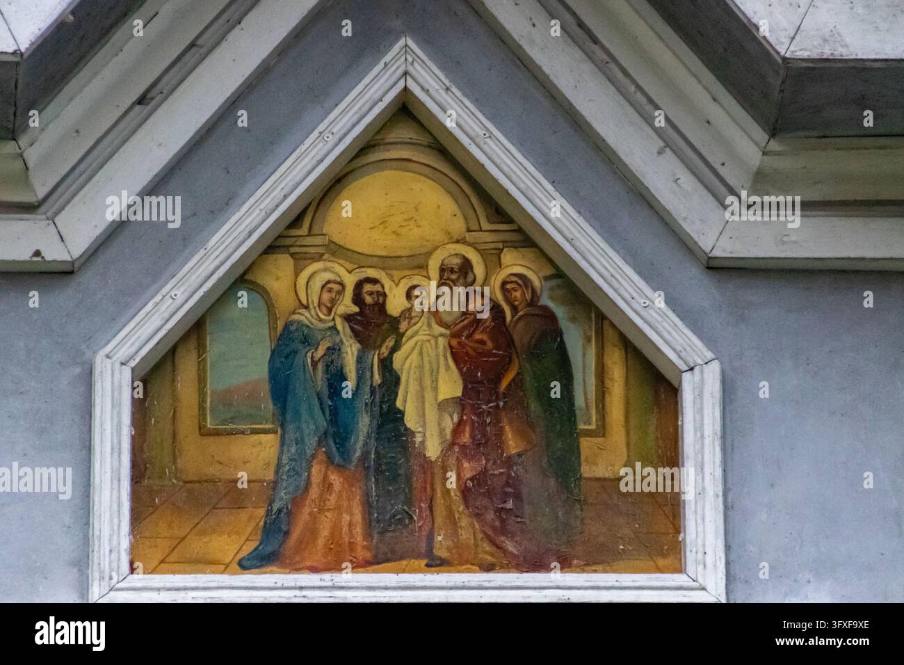 Un primo piano dettagliato di un affresco religioso ortodosso che raffigura personaggi biblici con aureole all'interno di una cornice architettonica triangolare bianca. Foto Stock