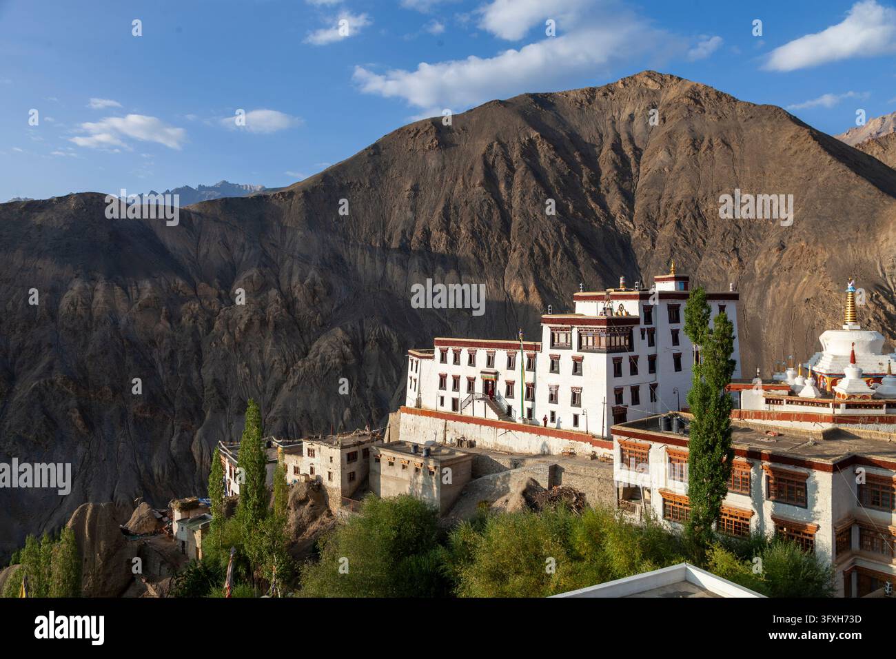 Edifici bianchi e una stupa del monastero di Yuru sotto una montagna arida nella luce calda, Ladakh, Lamayuru, India Foto Stock