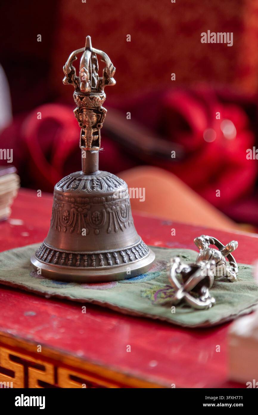Campana rituale buddista e vajra su un tessuto ricamato su un tavolo rosso al monastero di Yuru, Ladakh, Lamayuru, India Foto Stock