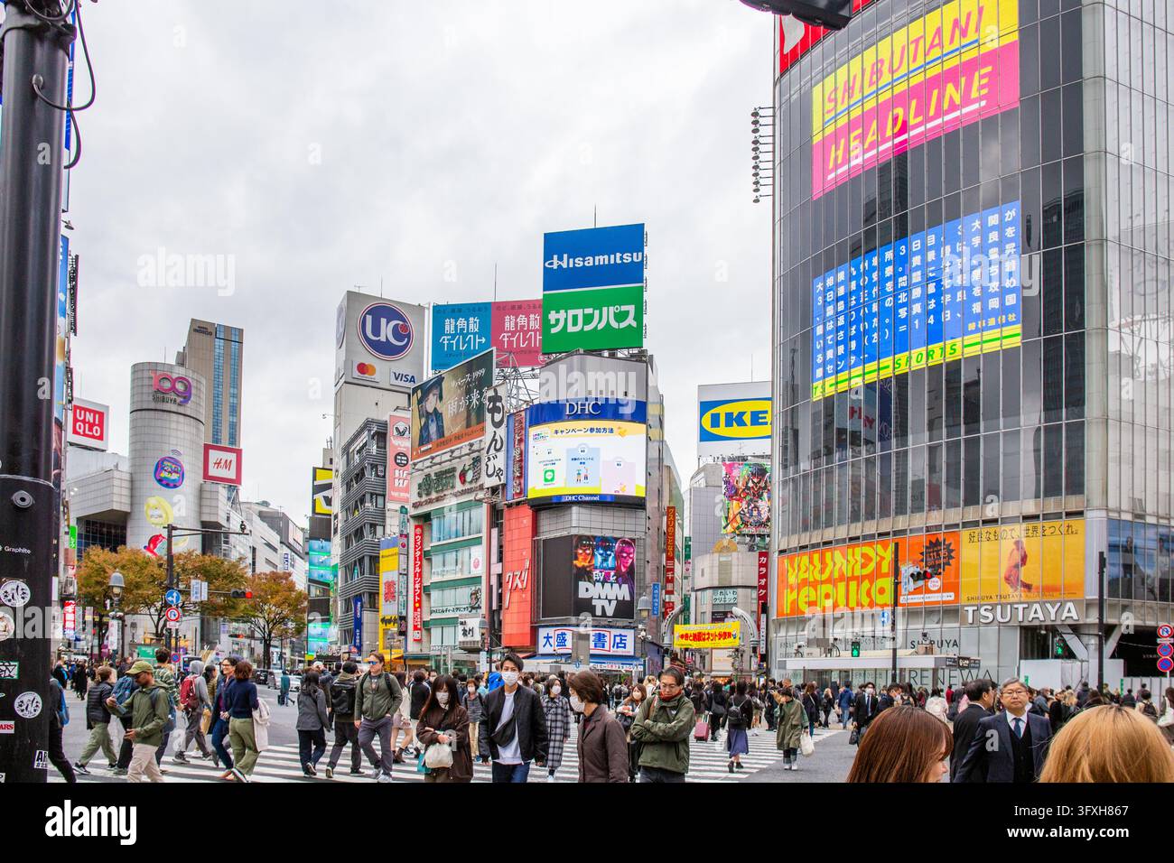 TOKYO, GIAPPONE - 15 novembre 2023: Molte persone e turisti, l'incrocio di Shibuya è un famoso punto di riferimento con molti negozi sullo sfondo. Foto Stock