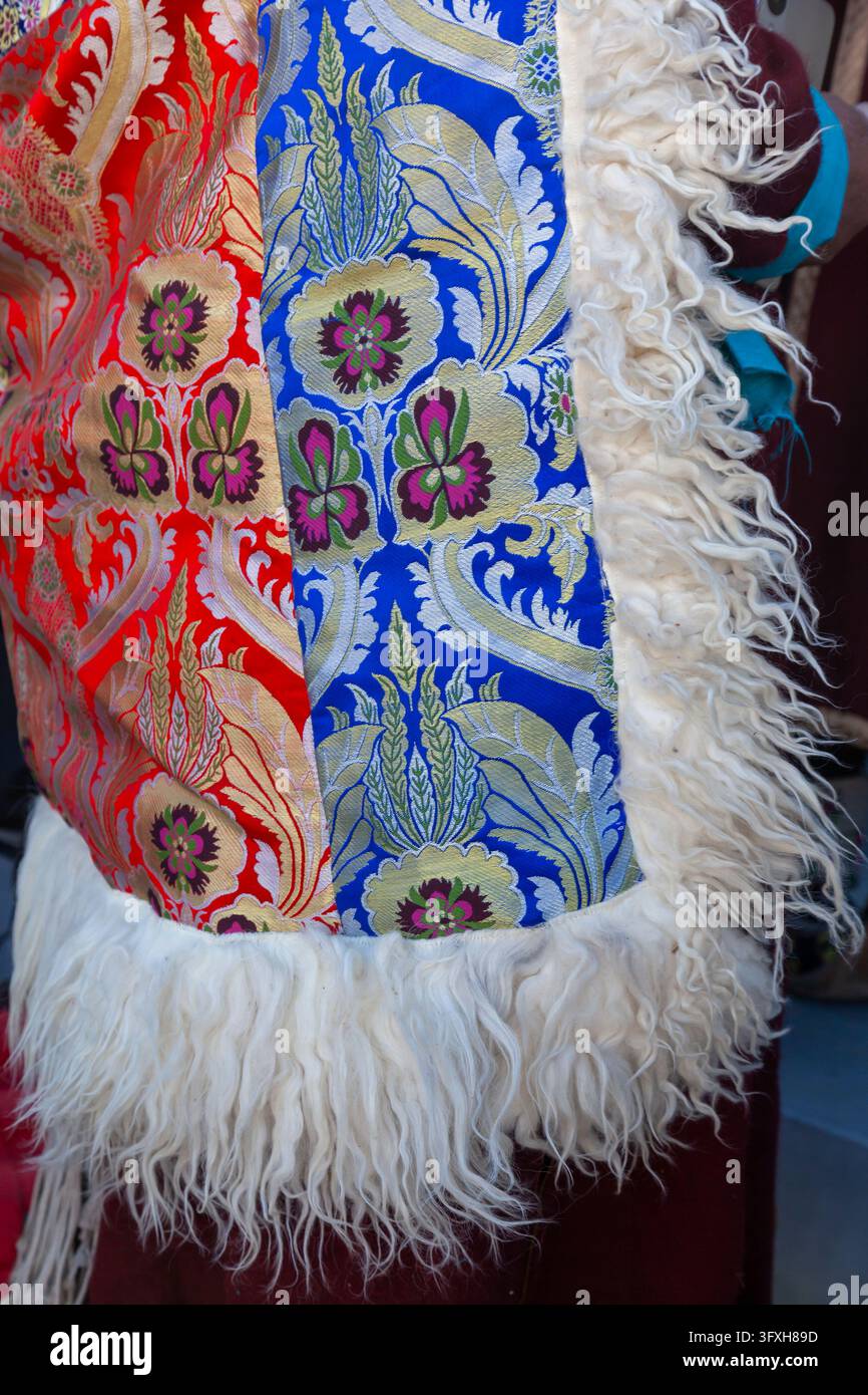 Prima vista di un mantello di broccato con motivi floreali e bordo in pelle di pecora bianca, Ladakh, Leh, India Foto Stock
