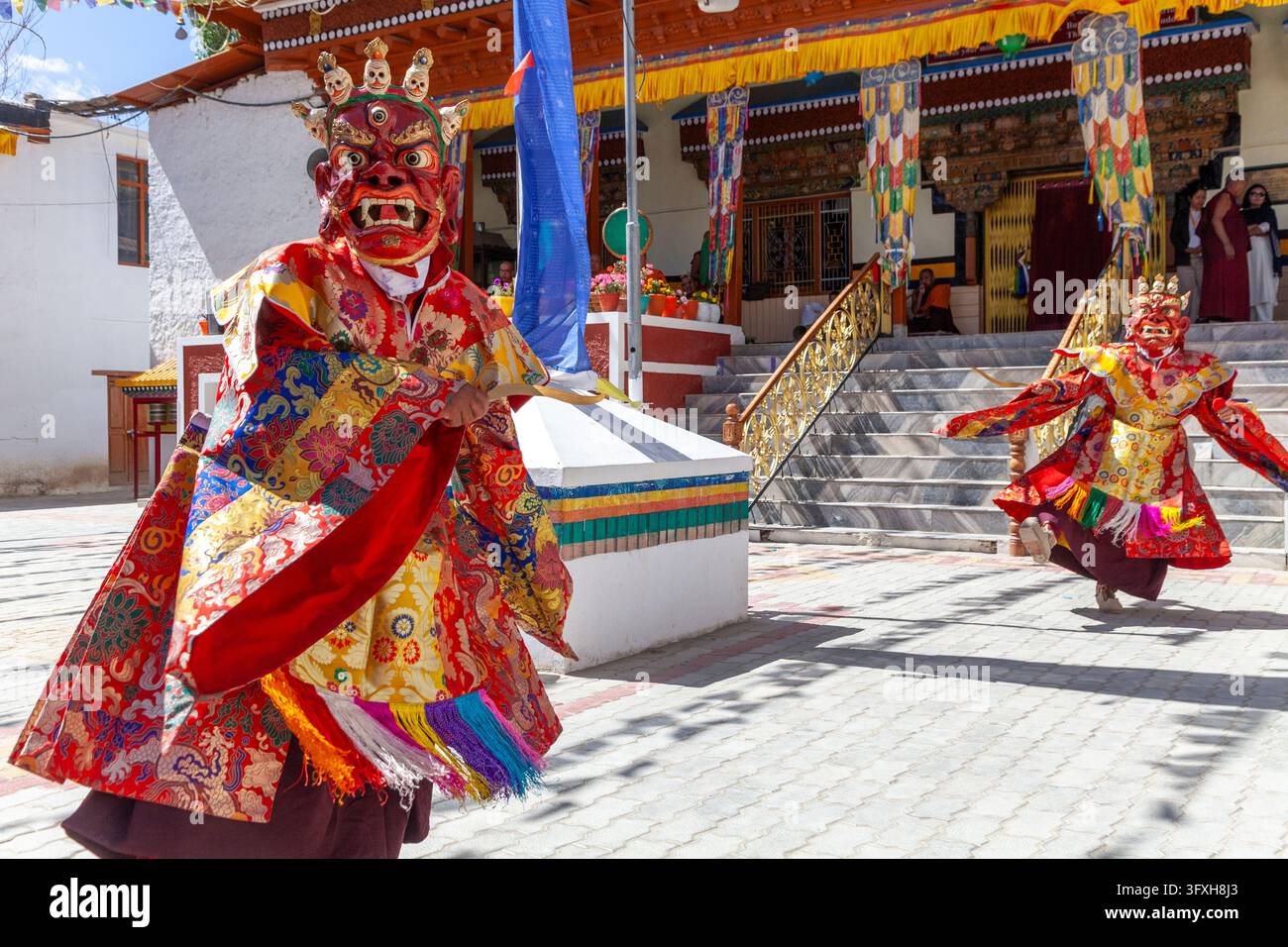 Danza Cham con lama mascherati che si esibiscono davanti a un tempio nel cortile di un monastero, Ladakh, Leh, India Foto Stock