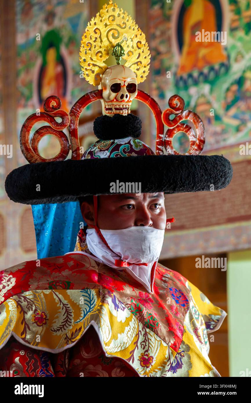 Prima piano di un lama che prepara la danza dei cappelli indossando un ampio cappello sormontato da un teschio e da un ornamento dorato, Ladakh, Leh, India Foto Stock