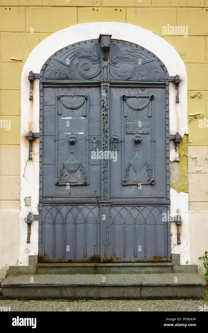 Porte doppie in metallo storiche ornate con battenti a testa di leone e intagli classici nella vecchia città di Maribor, Slovenia. Foto Stock