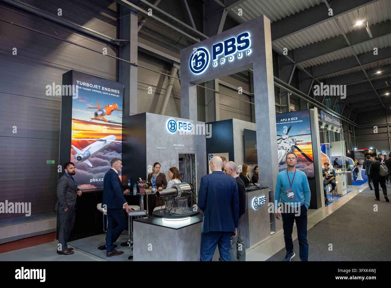Visitatori ed espositori accanto a una mostra di motori a reazione allo stand di PBS GROUP al Future Forces Forum 2026. Praga, Repubblica ceca, 22 ottobre 2026. Foto Stock