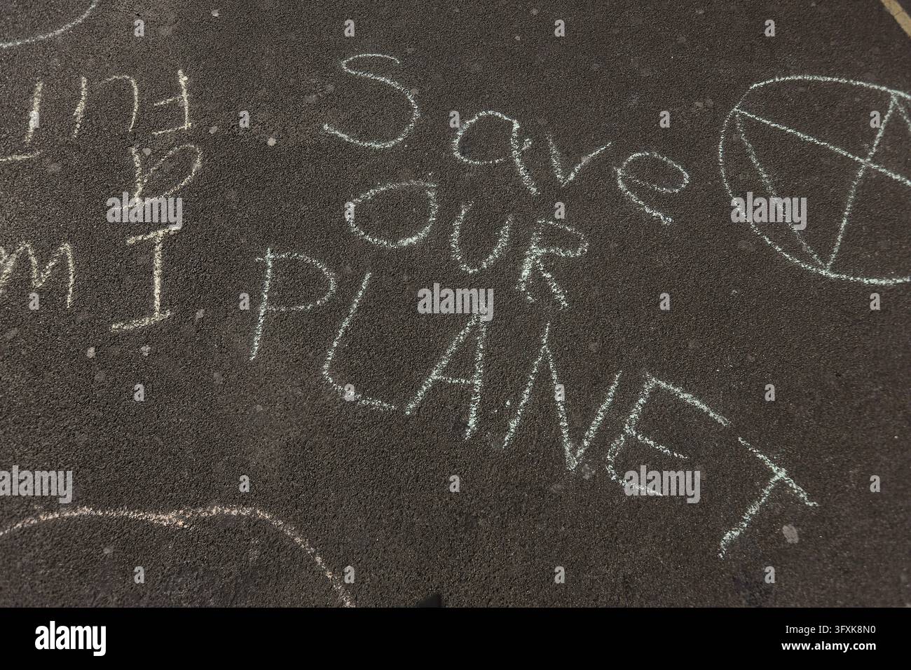 Londra, Regno Unito - 15 aprile 2019: Messaggio al gesso "Save Our Planet" scritto sull'asfalto con un disegno del globo. Foto Stock