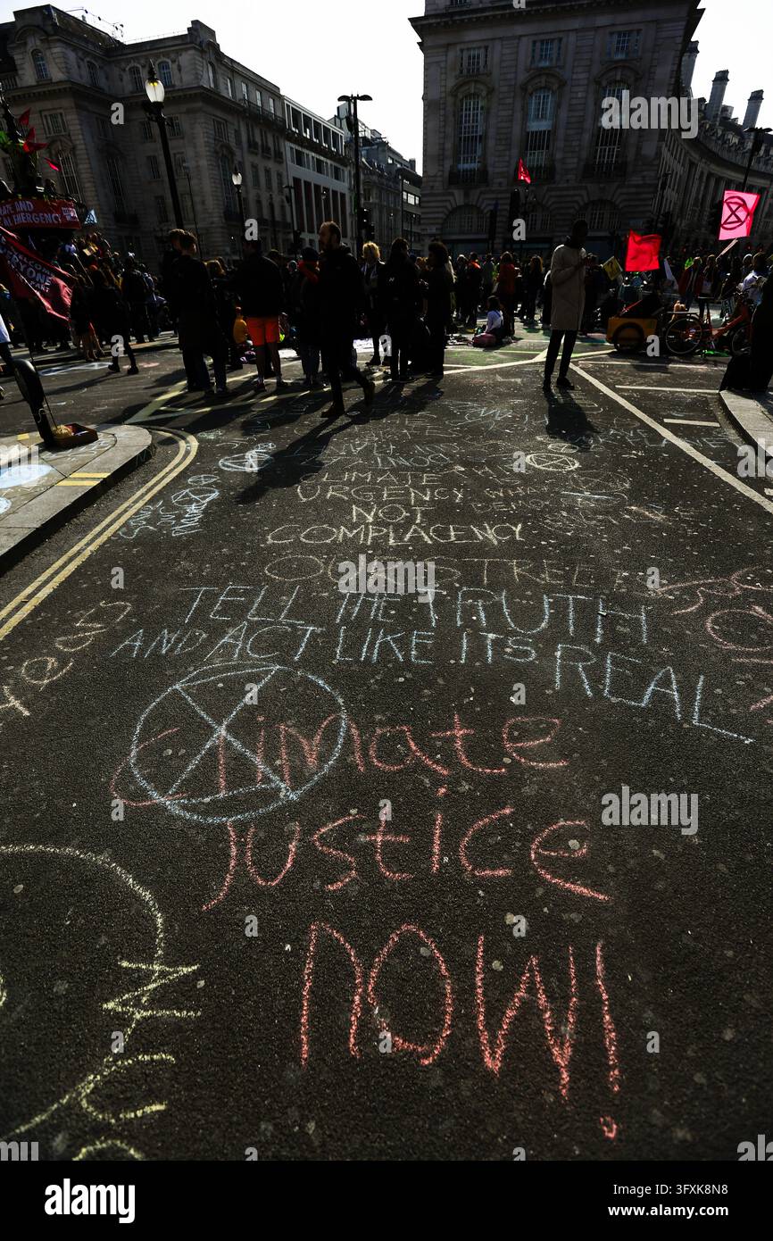 Londra, Regno Unito - 15 aprile 2019: I manifestanti si radunano in una strada con messaggi alla gesso che chiedono azione climatica e giustizia. Foto Stock