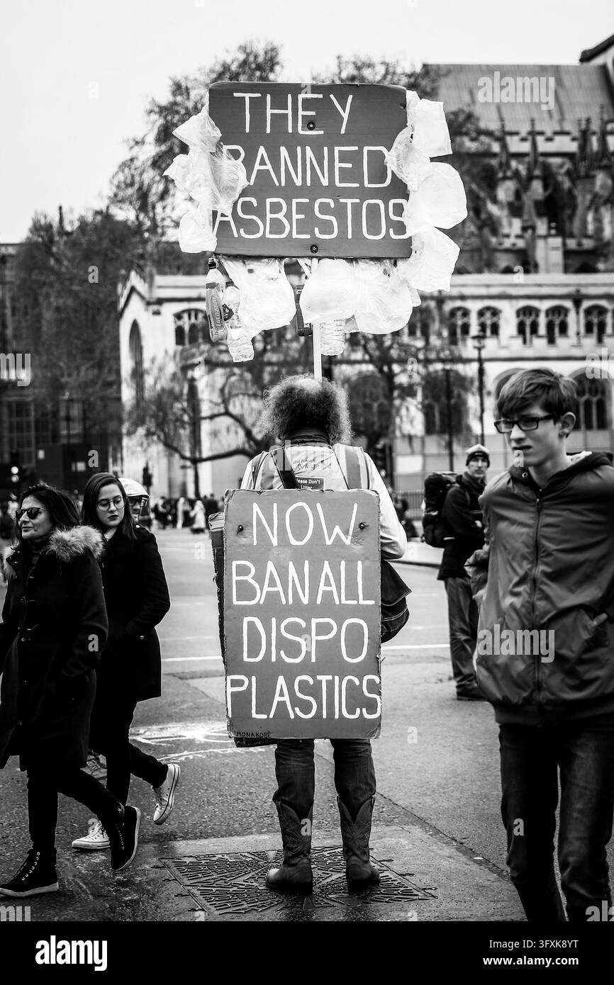 Londra, Regno Unito - 16 aprile 2019: Una persona tiene cartelli fatti a mano che chiedono il divieto della plastica monouso durante una manifestazione stradale. Foto Stock