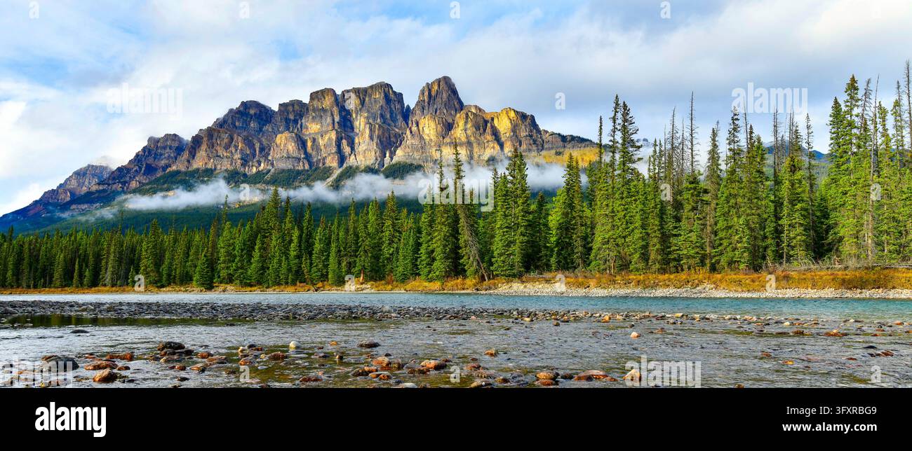 Maestoso picco del monte Castle con nuvole basse che si alzano sopra il fiume Bow nel Parco nazionale di Banff in Canada Foto Stock