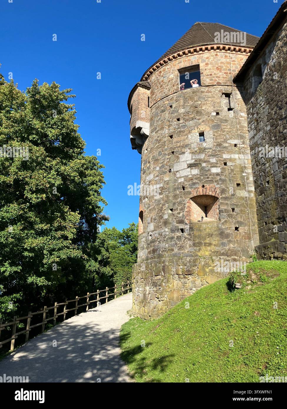 Vista panoramica di una torre di difesa in pietra al castello di Lubiana lungo un sentiero sulla collina del castello a Lubiana, in Slovenia, davanti a un cielo blu terso. - Immagine stock catturata con smartphone