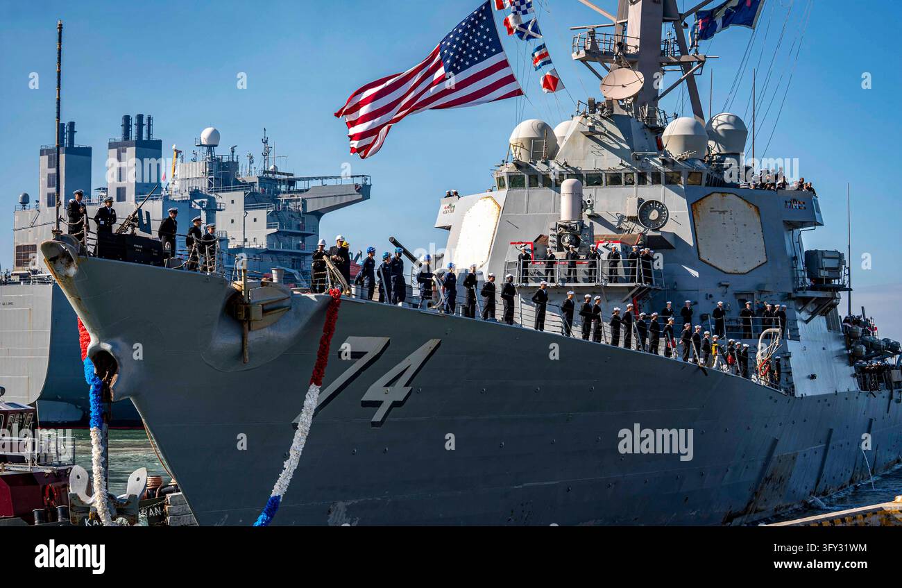 Norfolk, Stati Uniti d'America. 23 ottobre 2026. Marinai della U.S. Navy assegnati al cacciatorpediniere a missili guidati di classe Arleigh Burke USS McFaul (DDG 74) occupano le ringhiere durante il ritorno a casa della nave alla Naval Station Norfolk dopo un dispiegamento nelle aree operative della 5ª e 6ª flotta degli Stati Uniti, il 23 ottobre 2026 a Norfolk, Virginia. Crediti: MC2 Pierce Luck/U.S. Navy Photo/Alamy Live News Foto Stock