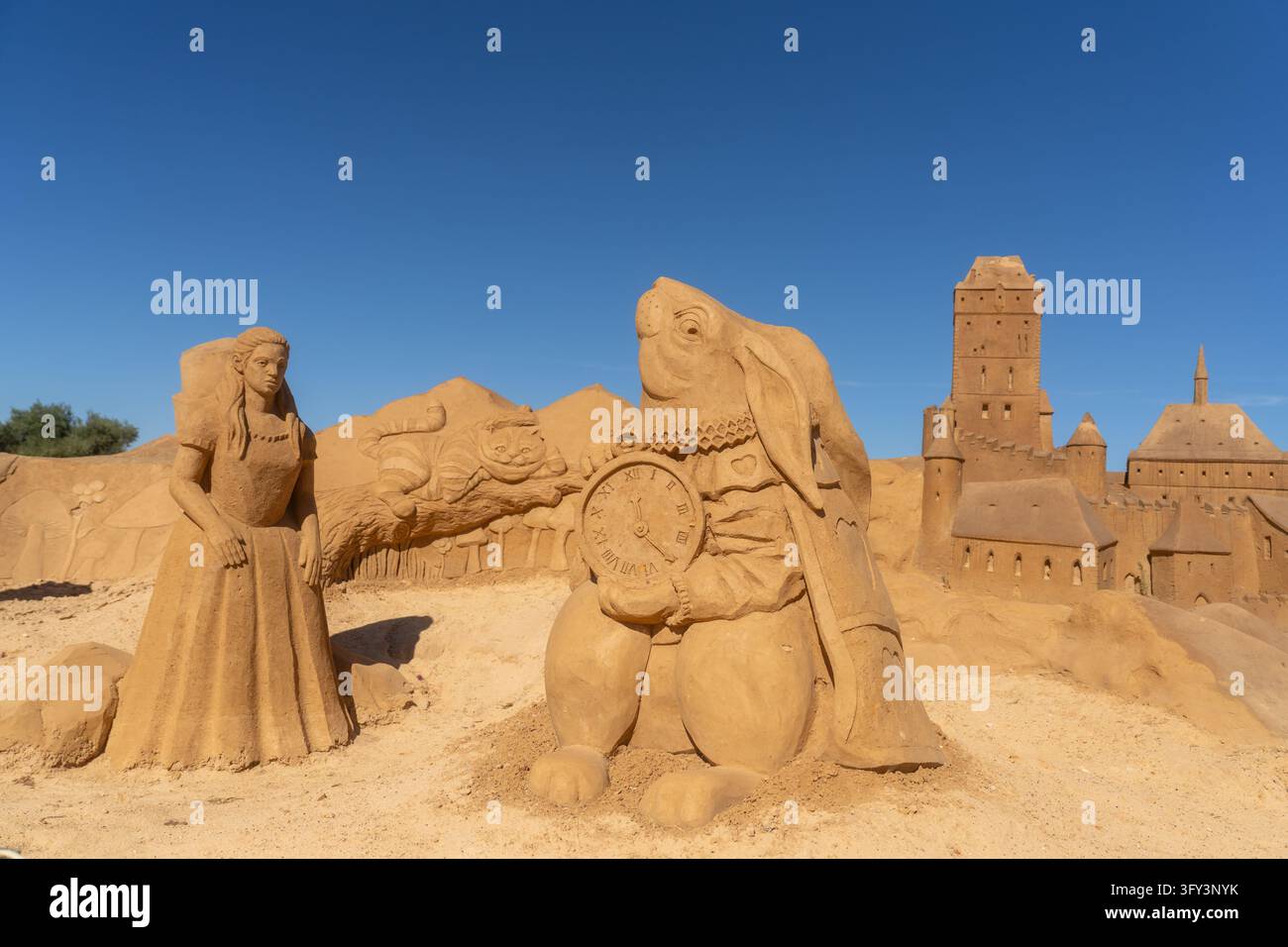 Lagoa, Portogallo, 22 ottobre 2026. Sculture di sabbia dettagliate ispirate ad Alice nel Paese delle Meraviglie, con Alice, il Coniglio Bianco con un orologio, e th Foto Stock