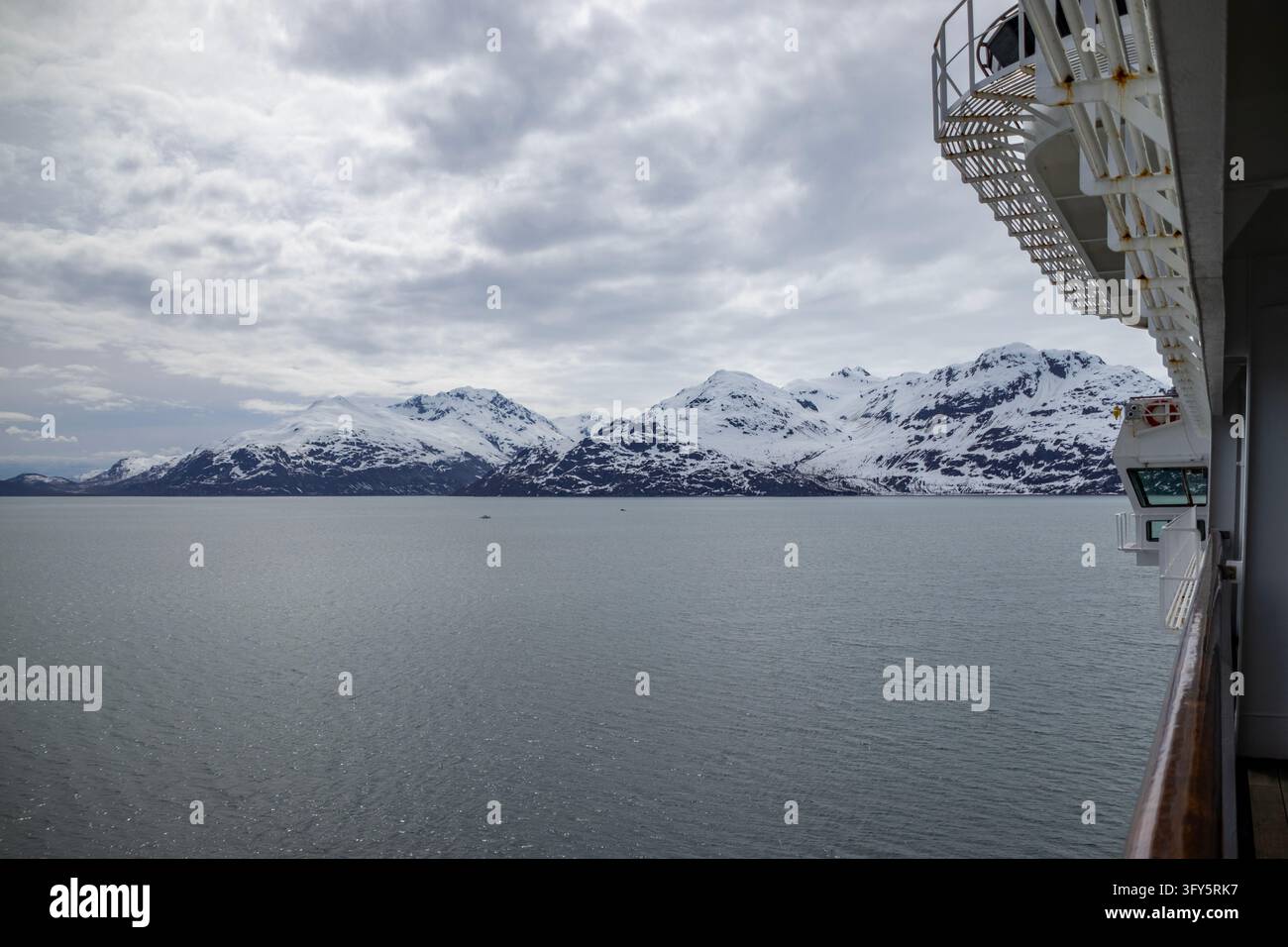 Vista di montagne innevate sopra acque calme dal balcone di una nave da crociera, Tarr Inlet, Parco nazionale e riserva di Glacier Bay, Alaska, USA, 24 maggio 2026 Foto Stock