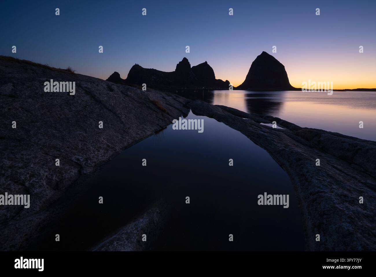 I picchi dell'isola di Sanna si ergono sopra piccole pozze di marea, Træna, Helgeland Foto Stock