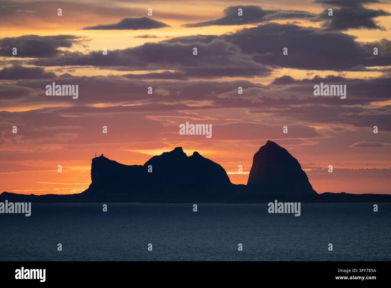 Le cime iconiche delle montagne di Sanna Træna si ergono nel cielo serale come viste Foto Stock