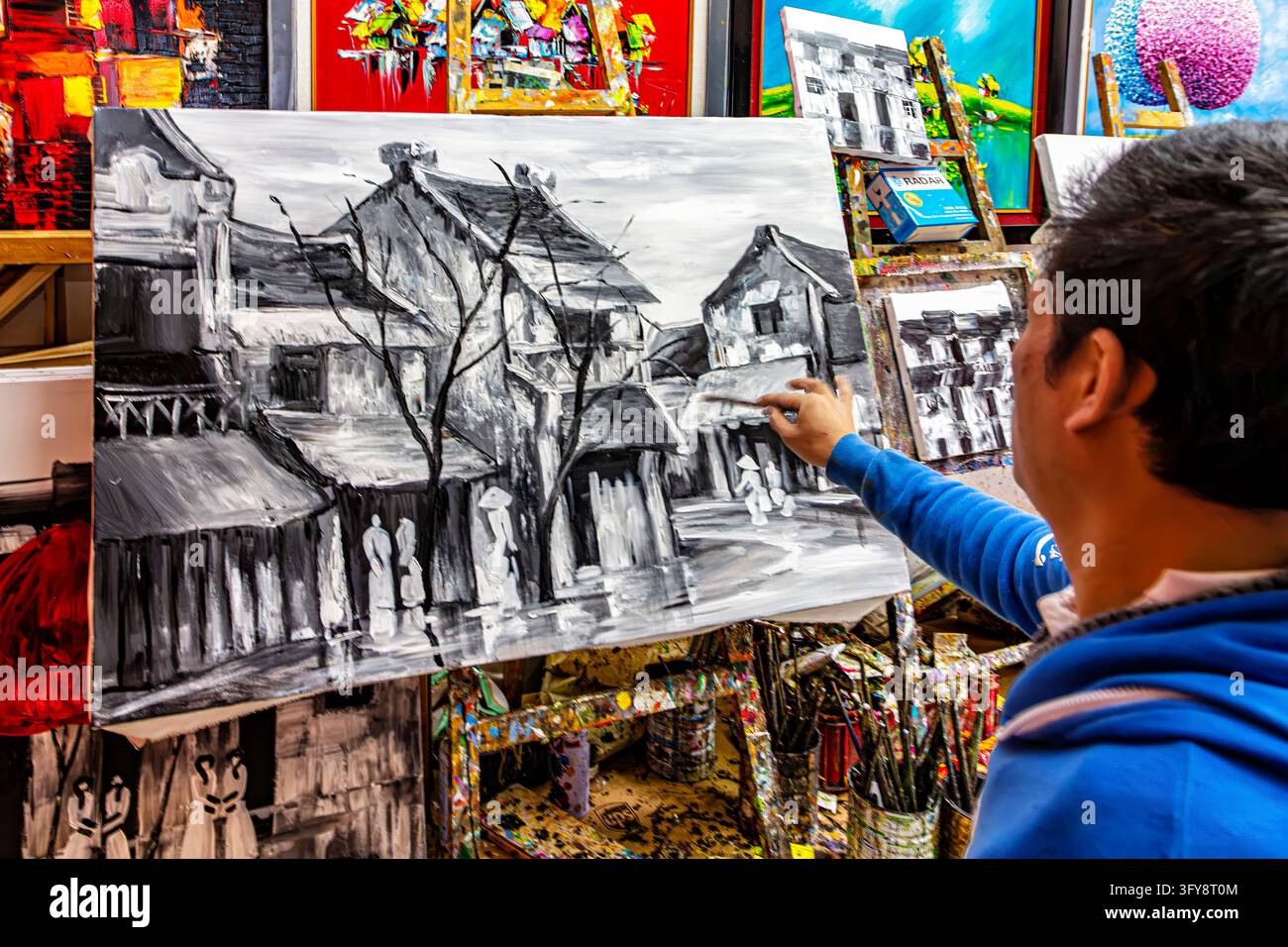 Artista vietnamita che disegna con una matita di carboncino in una galleria d'arte, Old Quarter, Hanoi, Vietnam Foto Stock