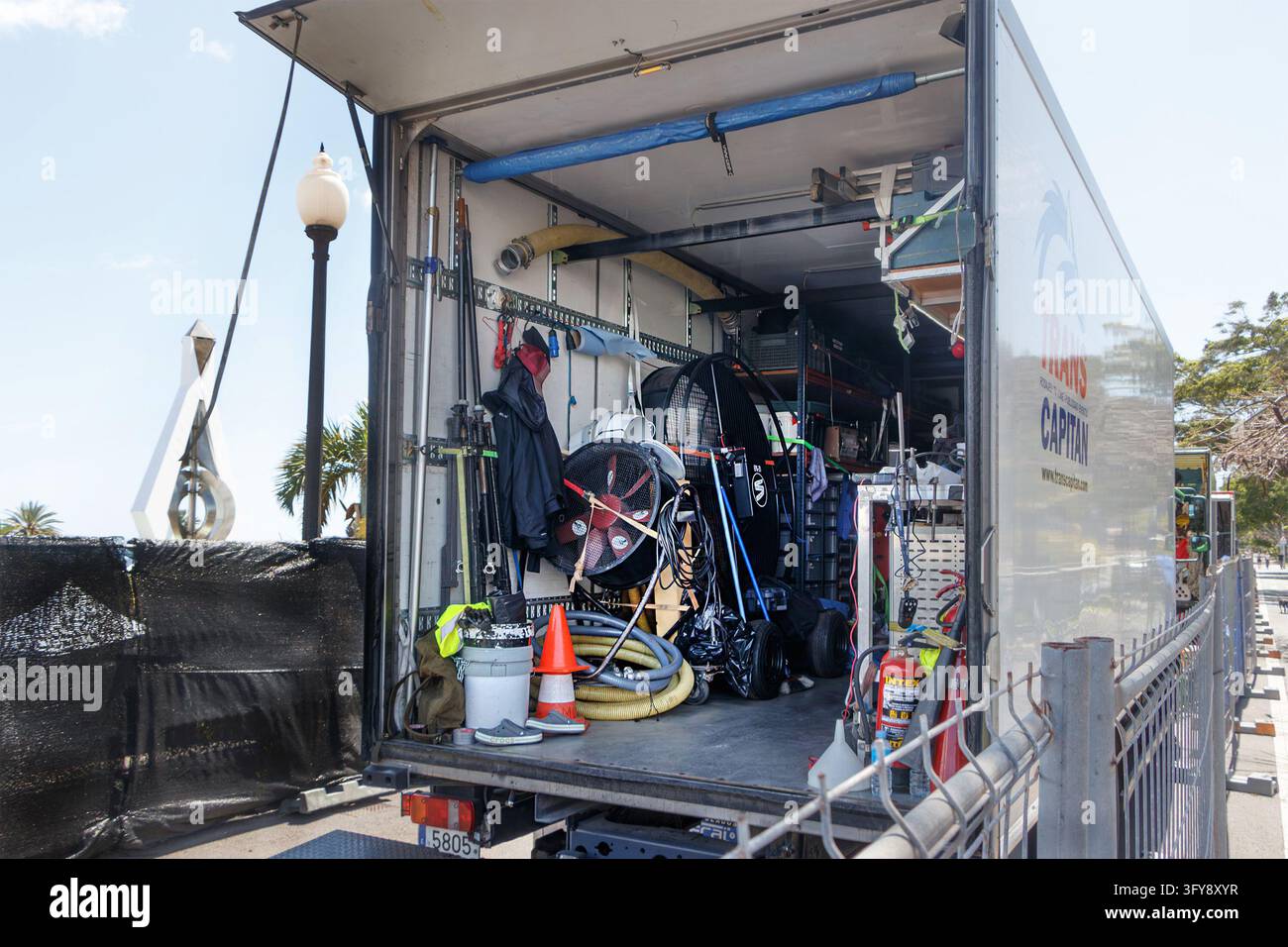 Interno del camion di produzione Trans Capitan bianco carico di attrezzature e equipaggiamento cinematografico, parcheggiato all'aperto dietro una recinzione Foto Stock