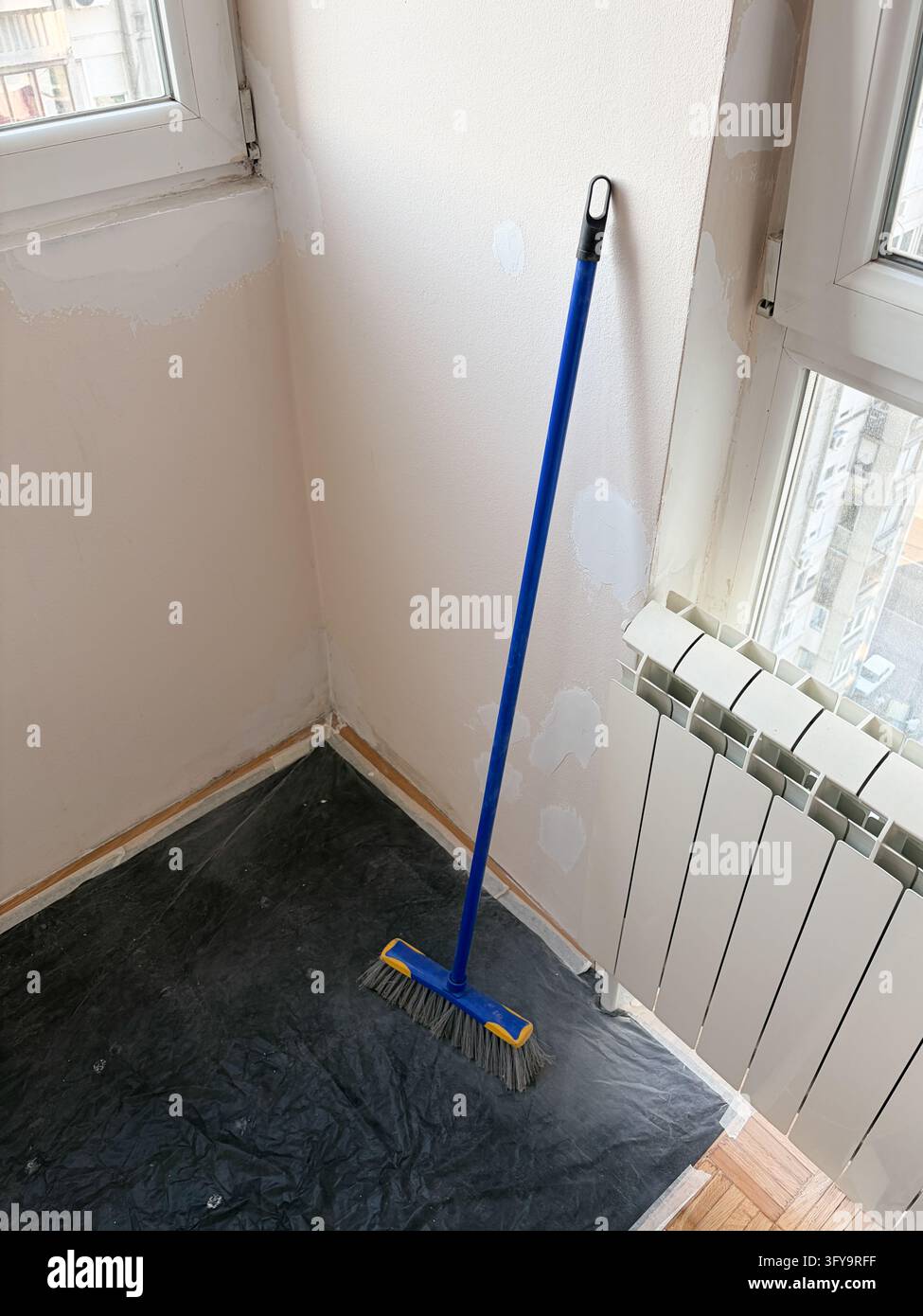Scopa in piedi su pavimento protetto nell'area di ristrutturazione dell'appartamento Foto Stock