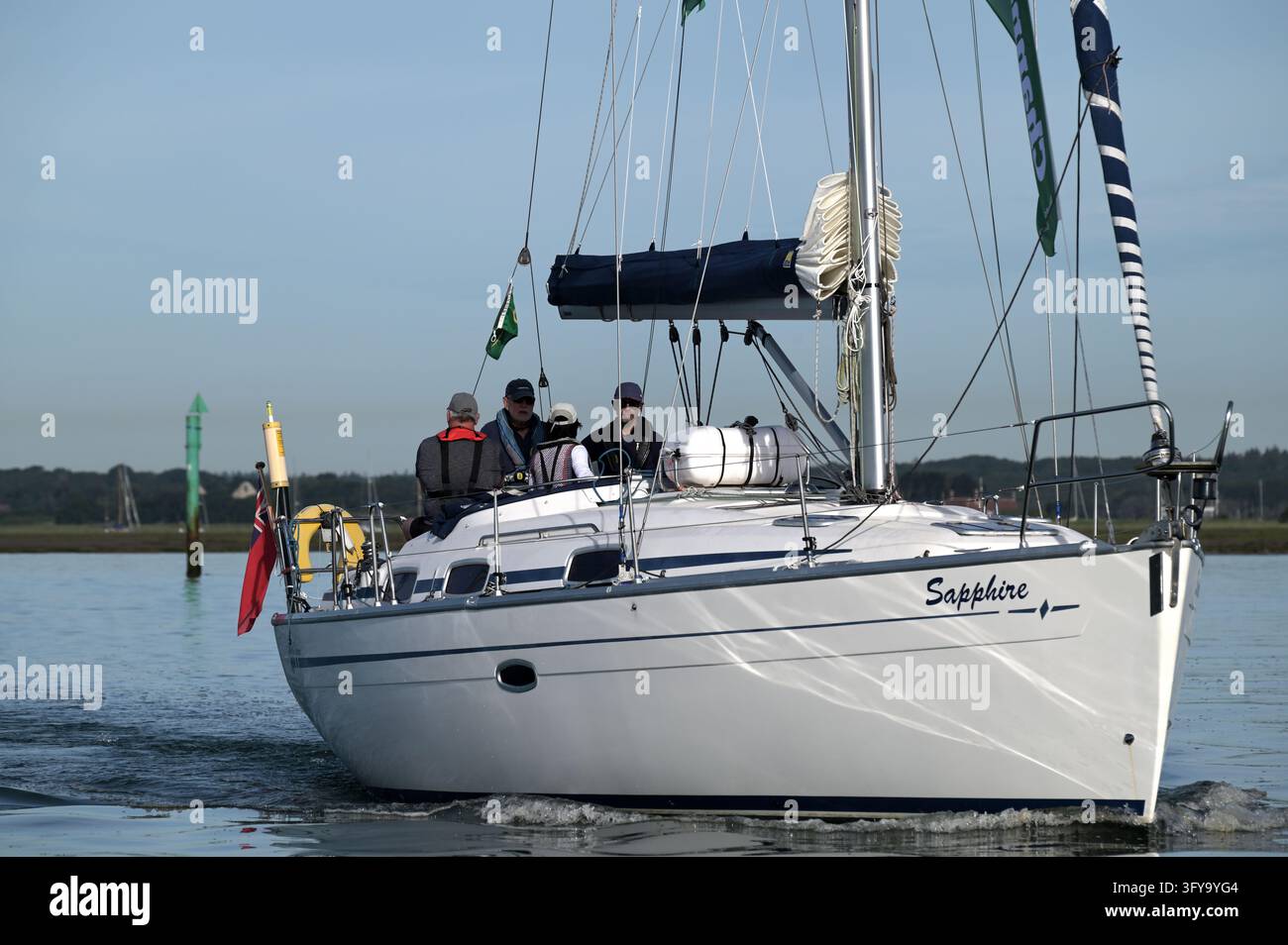 Yacht Sapphire con equipaggio che naviga a motore lungo il fiume Beaulieu nella calma luce del primo mattino, Hampshire, Regno Unito, 21 giugno 2026 Foto Stock