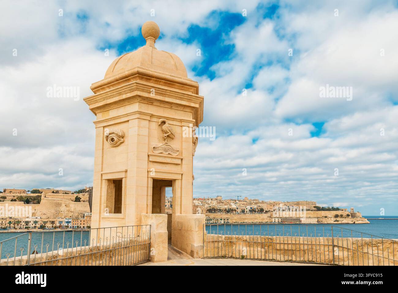 La torre di guardia di Gardjola con simboli di occhio e orecchio intagliati si affaccia sul Grand Harbour dalla città fortificata di Senglea, Malta. Fortificazioni maltesi Foto Stock