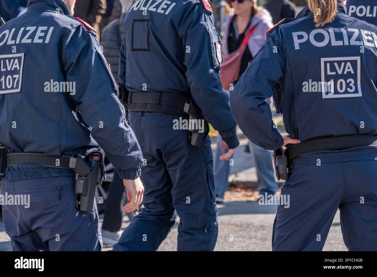 VIENA, AUSTRIA, 26 ottobre 2026: Tre agenti di polizia tedeschi sono visti di spalle durante un raduno pubblico all'aperto. Foto Stock