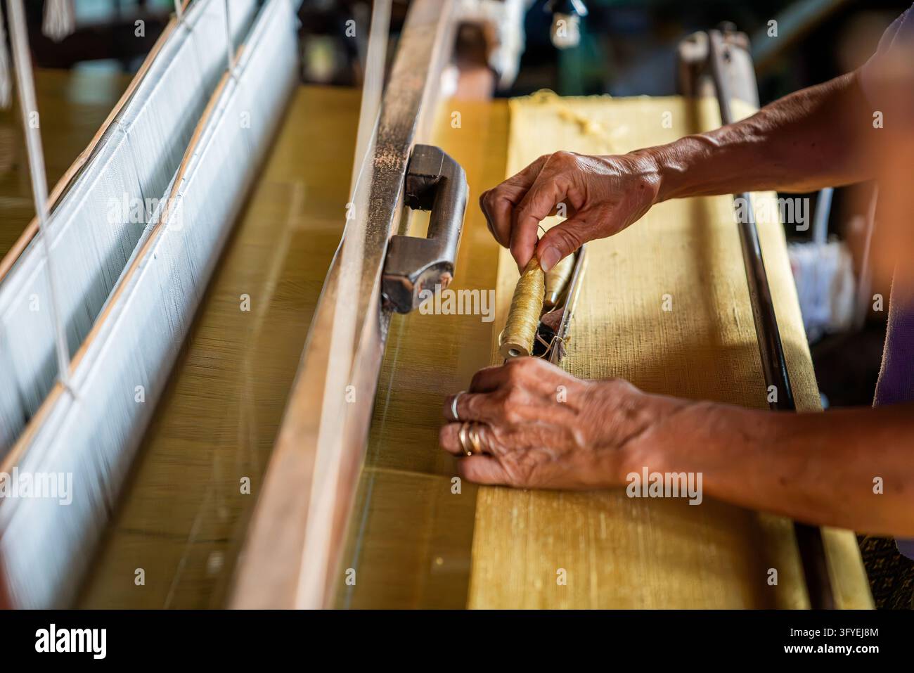 Un artigiano aziona un telaio tradizionale per tessere seta nella fabbrica di tessitura della seta Baan Kruu, i tessitori di seta originali che riforniscono Jim Thompsons a Ban Foto Stock