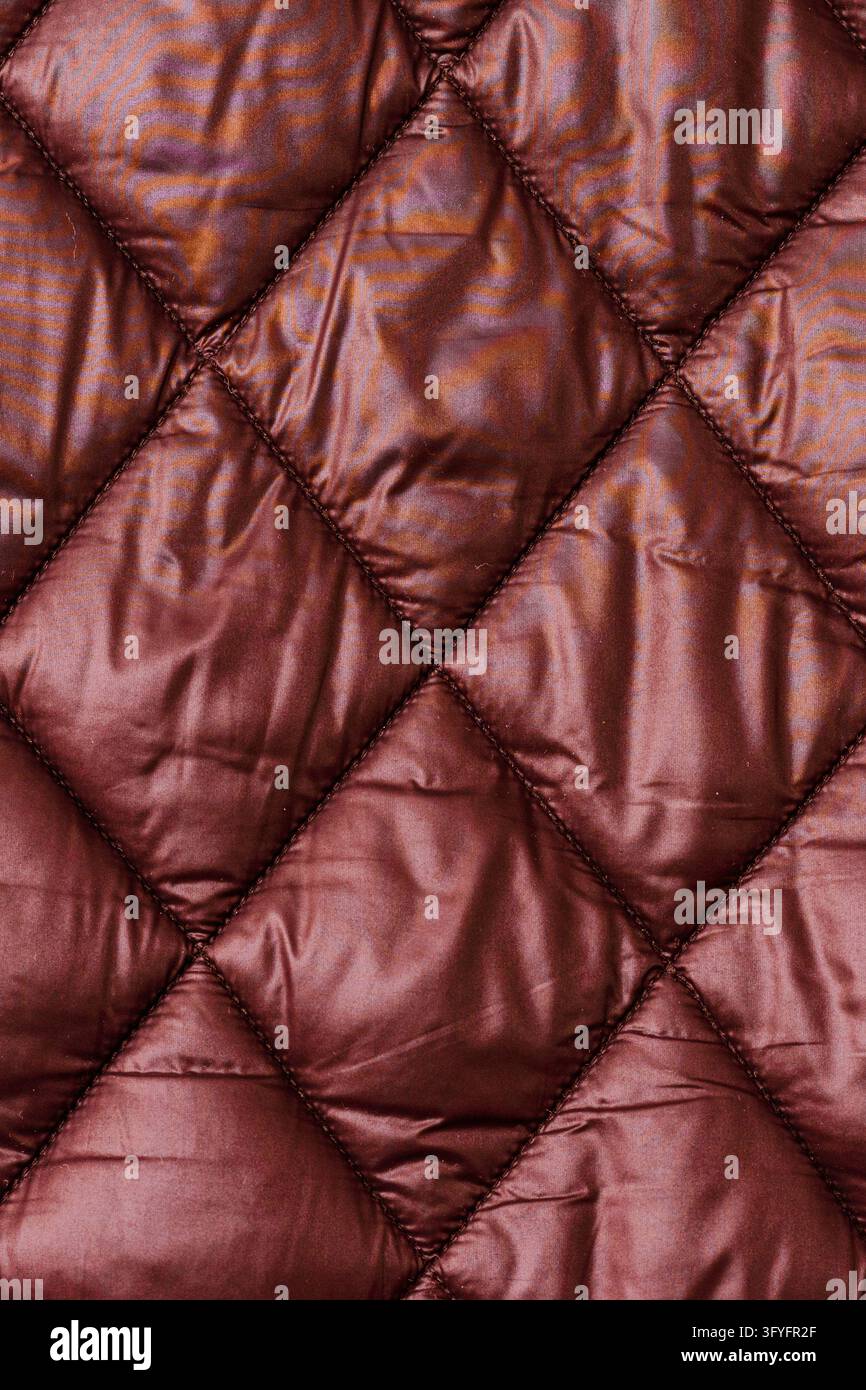 Texture di tessuto trapuntato bordeaux del materiale della giacca con spazio di copia verticale. Foto Stock