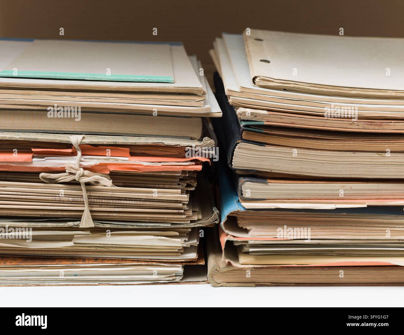 Prima vista di due pile di cartelle e documenti invecchiati, che simboleggiano dati aziendali, burocrazia e archivi. Foto Stock