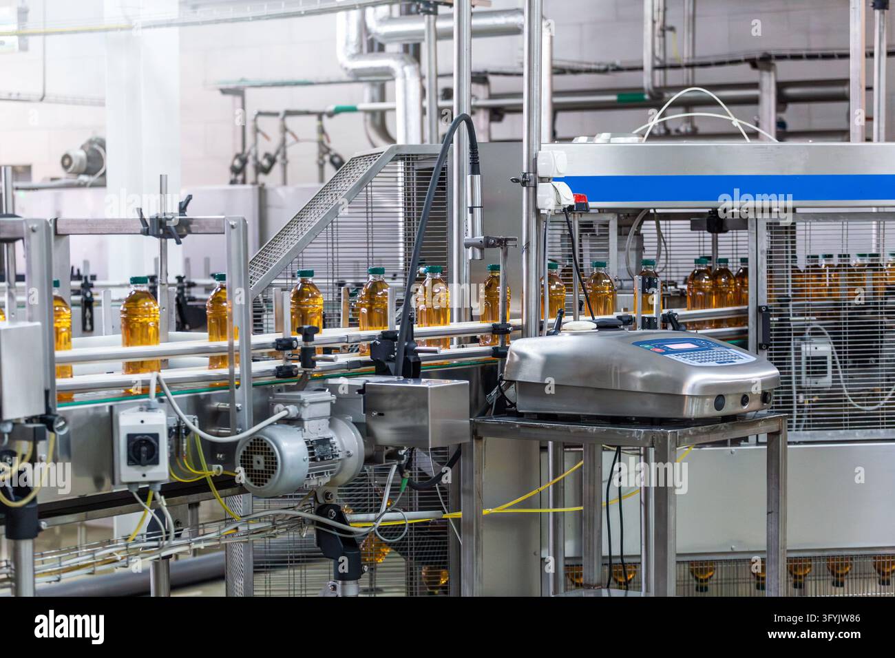 Automatizzazione industriale per l'imballaggio di bevande con trasportatore per bottiglie e attrezzatura di codifica in linea per la tracciabilità del prodotto e il controllo qualità in fabbrica. Foto Stock