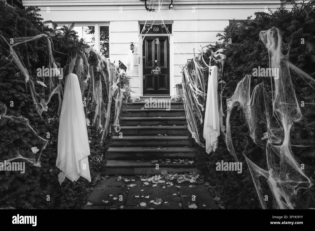 Scheletri e ragnatele che portano all'ingresso di una casa nel Kensington di Londra per Halloween. Foto Stock