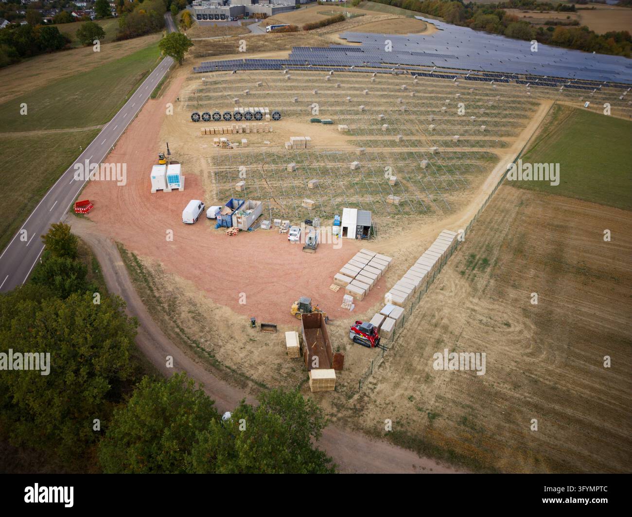Tholey, Saarland, Germania - 29 settembre 2026: Veduta aerea di un cantiere di costruzione di una fattoria solare con file di strutture di montaggio, attrezzature edili, Foto Stock