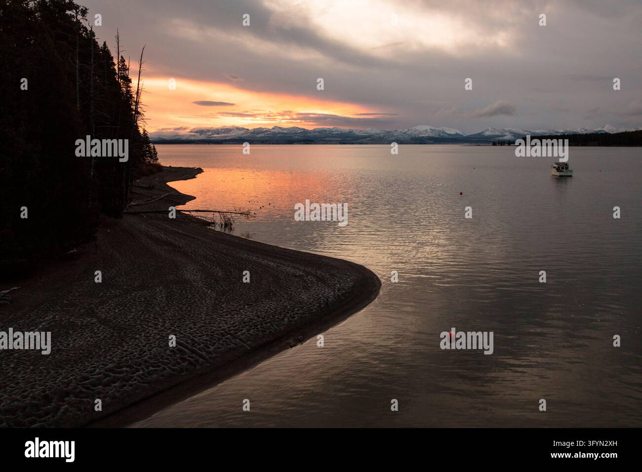 Una squadra di pescatori attraversa le acque tranquille del lago Yellowstone all'alba nel Parco Nazionale di Yellowstone, Wyoming, USA. La scena calma del mattino mostra lavoratori per il controllo delle specie acquatiche invasive che navigano la loro barca attraverso acque nebulose durante i lavori sul campo autunnali. Il lavoro evidenzia gli sforzi continui per la conservazione ambientale e la gestione delle risorse per preservare gli ecosistemi acquatici nativi all'interno del paesaggio iconico del parco nazionale. Una versione ottimizzata di un'immagine del US National Park Service. Credit: NPS / J Frank Foto Stock